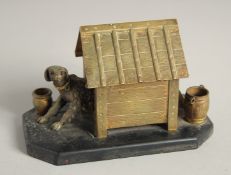 A BRONZE INKWELL, DOG IN A KENNEL on a marble base. 5ins long.