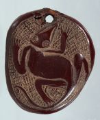 A NATIVE CARVED NUT PENDANT. 2.5ins x 2ins.