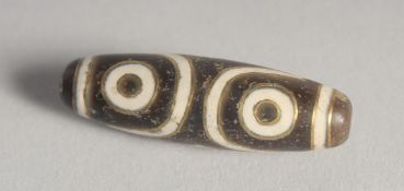 A GOLD INLAID DZI BEAD.