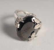 A SILVER AND BLACK STONE RING.