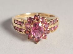 A 14CT GOLD RUBY CLUSTER RING.