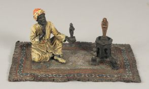 AN AUSTRIAN PAINTED COLD CAST GROUP, amulet vendor on a carpet. 7ins long.