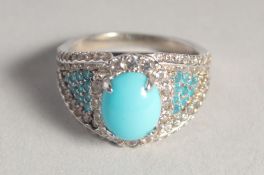 A SILVER AND TURQUOISE RING.