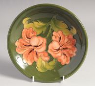 A MOORCROFT HIBISCUS CIRCULAR DISH. W. M. script in green, impressed, Moorcroft.