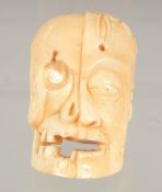 A CARVED BONE SKULL 2.5ins high.