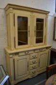 A large cream painted dresser with glazed upper section.