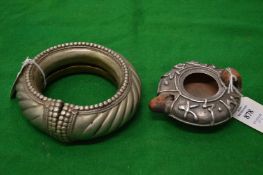 A silver mounted terracotta oil lamp and a large white metal bangle.