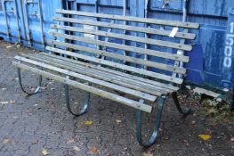 A wrought iron and wooden slatted garden bench.