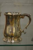 A silver baluster shaped tankard with scroll work handle.