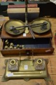 A brass inkstand, brass scales and weights with a mahogany base and three books.