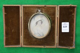 A leather cased oval portrait miniature of a lady wearing a white hat.