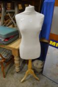 A dressmakers dummy on tripod base.