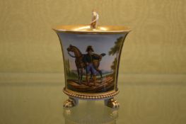 A French gilt porcelain cup painted with a horse and rider.