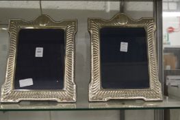 A pair of large silver photograph frames.