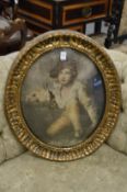 A pair of gilt framed oval colour prints depicting a young boy with a rabbit and a young girl.
