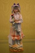 A bisque porcelain figure of a lady holding a chicken.