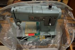 An electric Singer sewing machine with accessories.