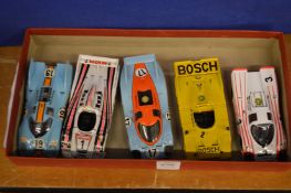 Five model Porsche racing cars.