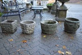 Four various composite garden planters.