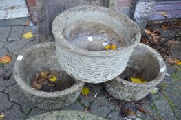 A pair of composite garden planters and a similar basket weave style planter.