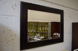 A large rectangular mirror with dark wood frame.