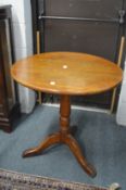 A mahogany circular tripod table.