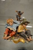 Capodimonte group of two young boys seated by a tree stump.
