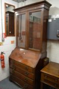 A Georgian mahogany bureau with later bookcase top.