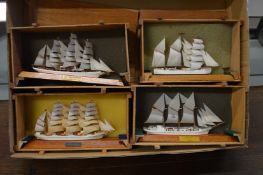 Four small models of sailing ships.