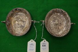 A pair of Continental silver twin handled oval dishes with embossed decoration.
