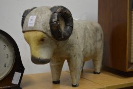 A carved and painted wood model of a ram.