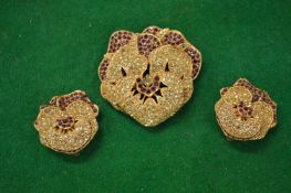 A decorative brooch and matching earrings signed Ciner.