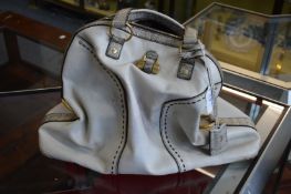 A ladies cream coloured handbag.