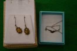 A pair of earrings and a necklace.