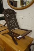 Decoratively carved folding occasional chair.