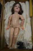 A good porcelain headed doll with articulated limbs.