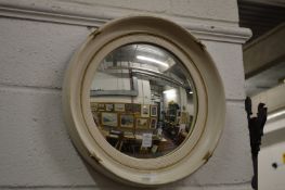 A white painted convex mirror.