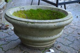 A large circular composite garden planter.