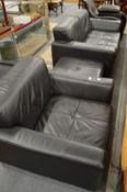 A black leather suite comprising two seater settee, armchair and foot stool.