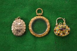 An engraved gold locket, a decorative clasp and miniature magnifying glass.