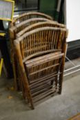 A set of four bamboo folding chairs.