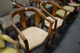 A pair of horseshoe shaped armchairs.