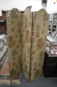A folding three panelled dressing screen upholstered in a medieval style fabric.