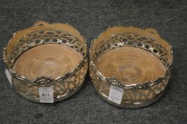 A pair of silver plated bottle coasters.