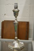 A silver candlestick converted to a table lamp.