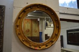 A gilt framed circular wall mirror.