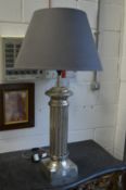 A large chromed metal column style table lamp.