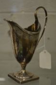 A George III silver helmet shaped cream jug with engraved decoration.