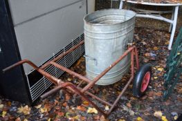 A wheeled galvanised water bucket.