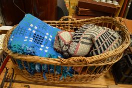 Wicker crib containing Welsh blankets and other textiles.